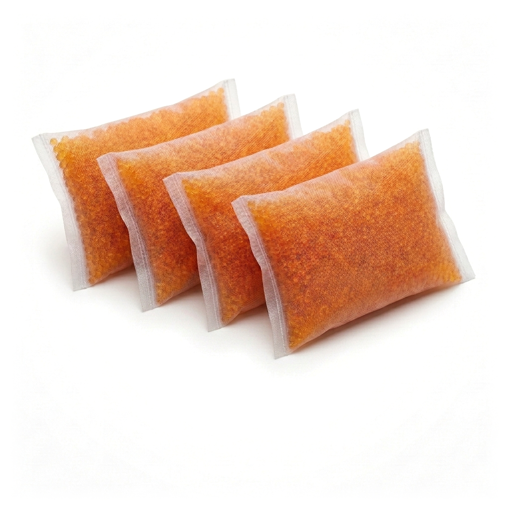 Four silica pouches with orange indicating silica gel in a fan row, on a white background