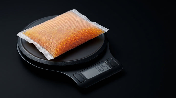 Silica gel mesh pouch on a black digital kitchen scale reading 10.5 grams